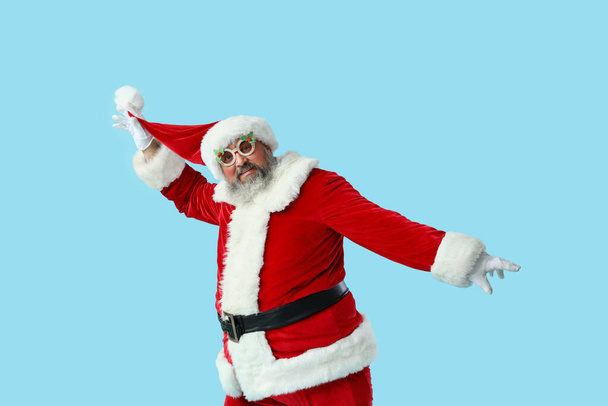 Funny Santa Claus dancing on blue background - Photo, Image