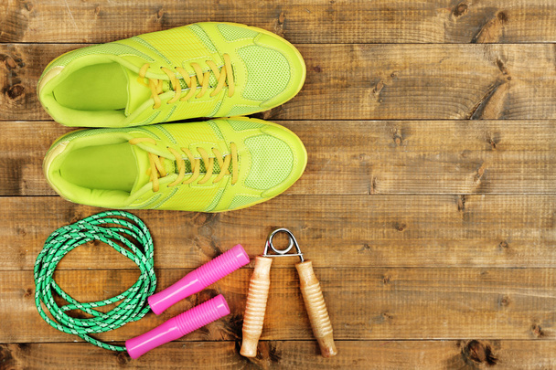 Shoes and sports equipment on wooden floor, top view - Foto, afbeelding