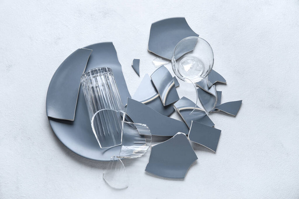 Broken glasses and plate on light background - Photo, Image