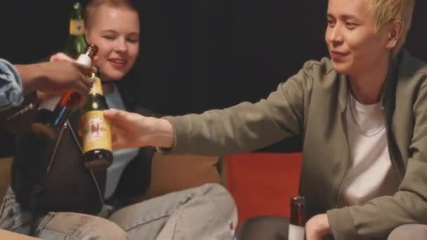 Odchyl się od rozmaitych młodych hipsterskich przyjaciół brzęczących butelkami piwa i cieszących się razem czasem podczas weekendowego spotkania w apartamencie - Materiał filmowy, wideo
