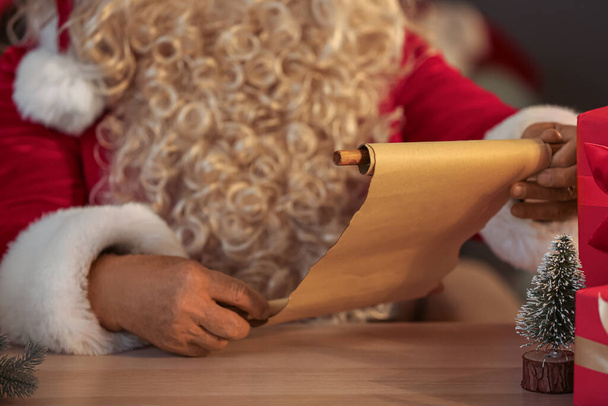Santa Claus reading letter at home on Christmas eve, closeup - Photo, Image