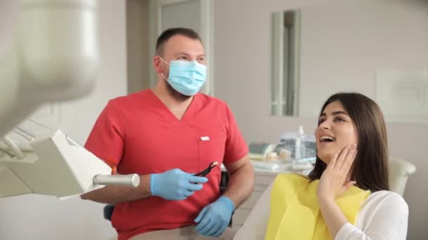 歯科医は現代の診療所で歯を治療しています. 歯に痛みがある。 痛みのない歯科治療. - 映像、動画