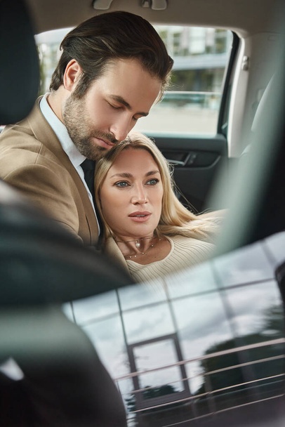 elegáns üzletember csukott szemmel ölelés érzéki szőke nő luxus autó, szerelem viszony - Fotó, kép