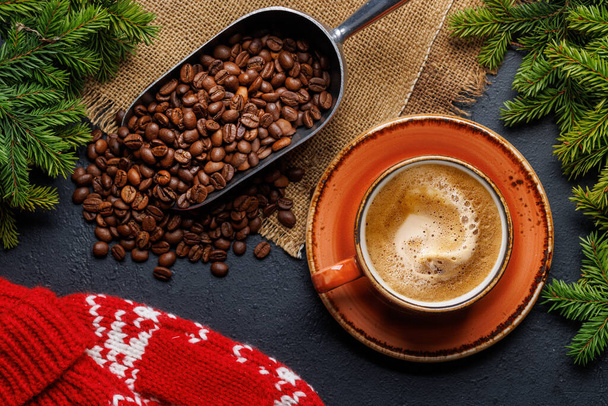 Kaffeetasse, geröstete Kaffeebohnen und Tannenzweige in gemütlicher Atmosphäre. Flache Weihnachtskarte - Foto, Bild