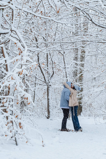 Paar umarmt sich im verschneiten Wald - Foto, Bild