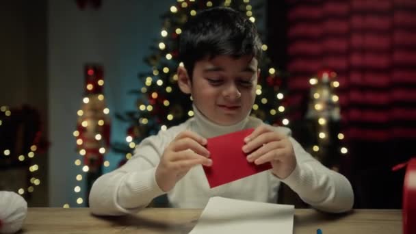 Lapsi laittaa hänen Kirje sisällä Santa Letterbox.  - Materiaali, video