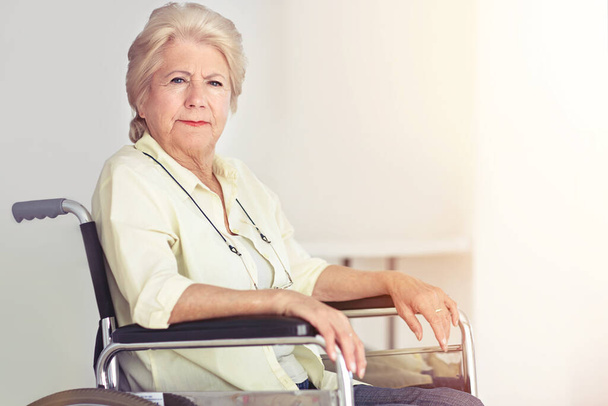 Yaşlılık, hayatın tacı, son oyunlarımız. Evinde tekerlekli sandalyede oturan son sınıf bir kadının portresi. - Fotoğraf, Görsel