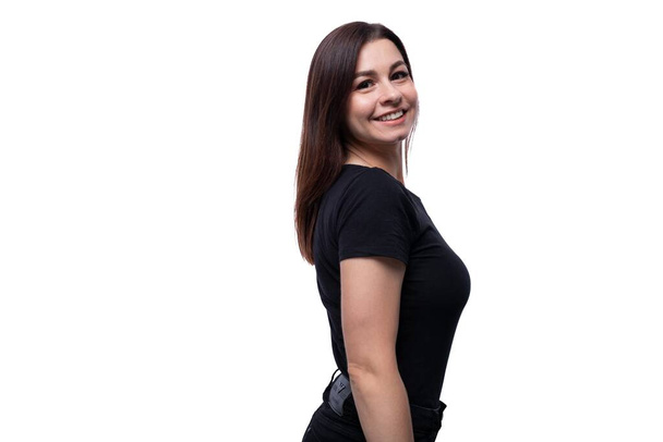 Ritratto di una giovane donna bruna vestita con una maglietta nera su uno sfondo bianco da studio. - Foto, immagini