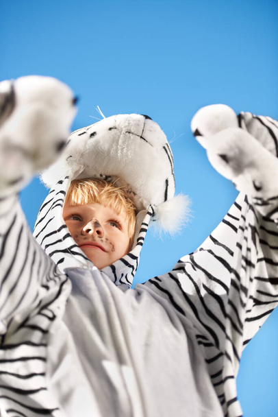 Η στολή μου είναι η καλύτερη. Μικρό παιδί που φοράει στολή τίγρης με τα χέρια του σηκωμένα - Φωτογραφία, εικόνα