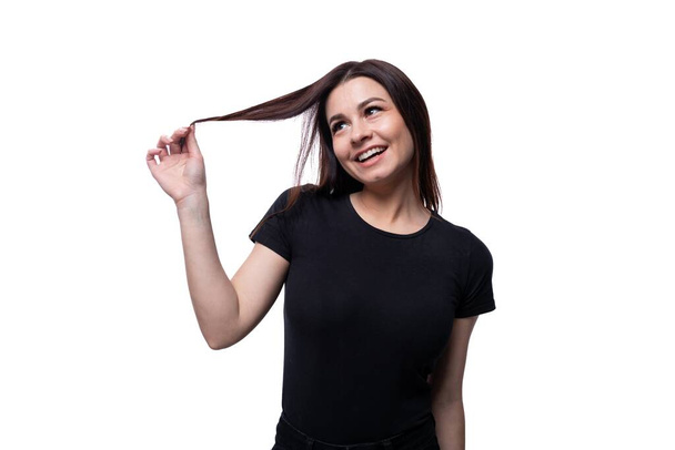 Jeune femme brune élancée aux cheveux courts et raides portant un T-shirt noir. - Photo, image