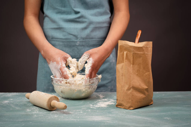 Baker vaivaamalla taikina käsityöläinen leipää tai pizzaa käsillään, valmistaa ainesosia ruokaa, leivonnaisia  - Valokuva, kuva