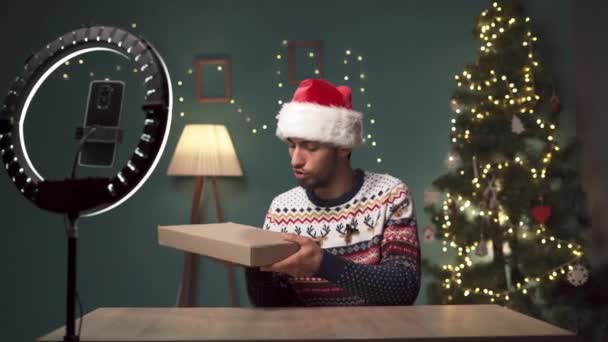 Arabische man unboxing pakket met laptop op camera, jonge oostelijke blogger opnemen van video-inhoud voor tech blog thuis met Kerstmis. Kopieerruimte - Video