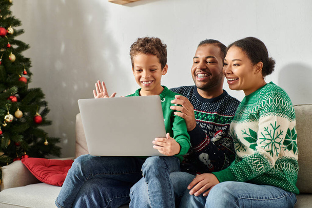 Χαρούμενη αφροαμερικανική οικογένεια που περνούν χρόνο μαζί, ενώ ο γιος χαιρετώντας laptop κάμερα, Χριστούγεννα - Φωτογραφία, εικόνα
