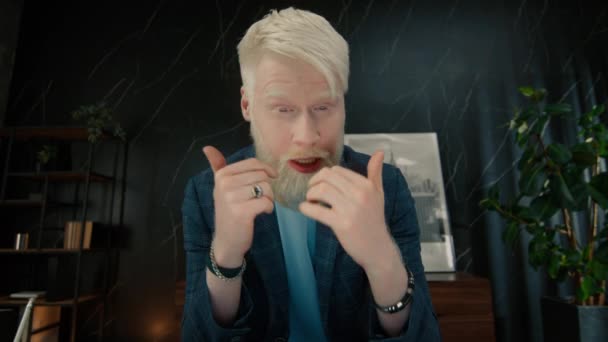 Gestresste albino zakenman in gesprek met collega 's via online videogesprek. Boze mannelijke leidinggevende bespreekt werkplannen per videoconferentie in het kantoor. Gericht manager gebaren handen - Video