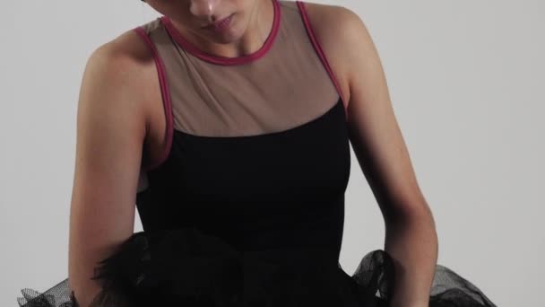 Ballerina im schwarzen Kleid, die im Studio Spitzenschuhe anzieht. Mittelschuss - Filmmaterial, Video