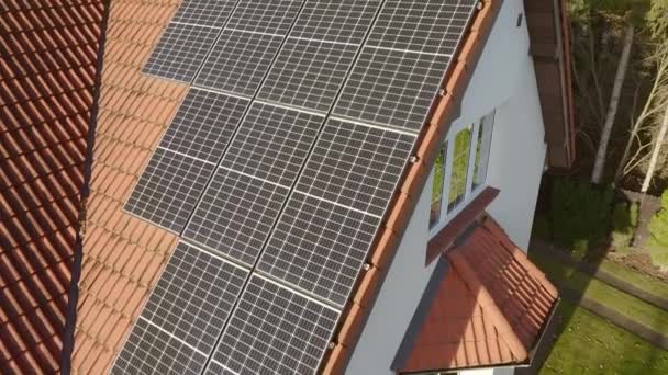 Moderne fotovoltaïsche monokristallijne zonnecellen van vast siliciumkristal met een hoog rendement van het omzetten van zonlicht in elektriciteit worden geïnstalleerd op het betegelde dak van een particulier huis. - Video