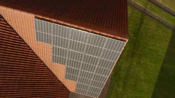 Zonneschijn op fotovoltaïsche monokristallijne zonnecellen gemaakt van één siliciumkristal, met een verhoogde efficiëntie van het omzetten van zonlicht in elektrische stroom op het betegelde dak van het huis. - Video