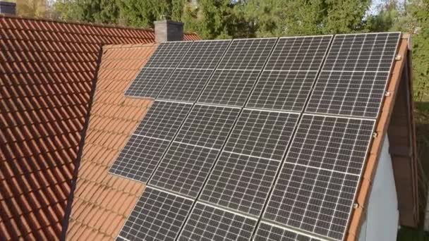 Auf dem Ziegeldach eines Privathauses sind Photovoltaik-Solarzellen installiert. Ein mit Solarenergie betriebenes Haushaltsstromversorgungssystem, um die Kosten für die Bezahlung von Stromrechnungen zu senken. - Filmmaterial, Video