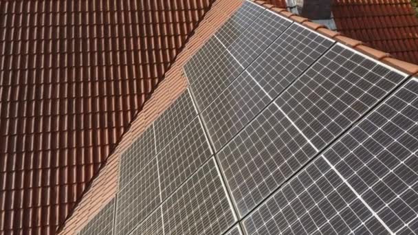 Fotovoltaïsche zonnepanelen worden geïnstalleerd op het betegelde dak van een particulier huis. Elektriciteitsvoorziening van huishoudens op basis van zonne-energie om de kosten van het betalen van elektriciteitsrekeningen te verlagen. - Video