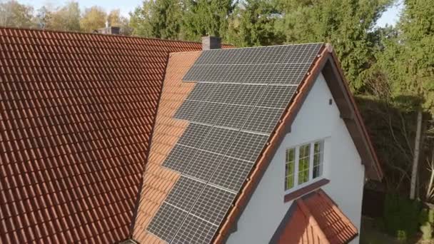 A fotovoltaikus napmodulokat egy magánház csempézett tetejére szerelik fel. Napenergiával működő háztartási villamosenergia-ellátó rendszer a villamosenergia-számlák kifizetési költségeinek csökkentésére. - Felvétel, videó