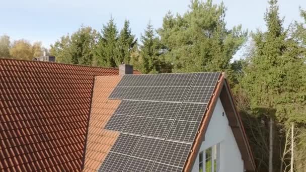 Fotovoltaikus napelemekből álló háztartási rendszer, amelyet egy magánház csempézett tetejére szereltek. Magánházak villamosítása. - Felvétel, videó
