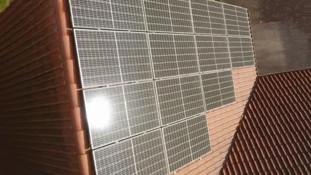 Sonnenblendung auf Photovoltaik-Solarmodulen, die auf dem Ziegeldach eines Privathauses installiert sind. Ein mit Solarenergie betriebenes Haushaltsstromversorgungssystem, um die Kosten für die Bezahlung von Stromrechnungen zu senken. - Filmmaterial, Video