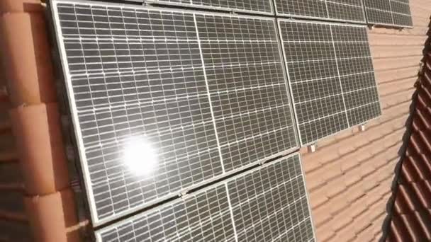 Zonnestraling op het oppervlak van fotovoltaïsche zonnemodules om elektriciteit op te wekken uit zonne-energie op het dak van het huis. Apparatuur voor de energievoorziening uit hernieuwbare energiebronnen. - Video