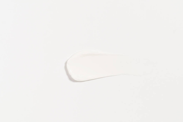 textura bílé šmouhy smetany na izolovaném pozadí. koncepce kosmetických výrobků pro hydrataci a péči o pleť - Fotografie, Obrázek