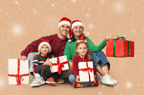 Happy family with Christmas presents on beige background - Photo, Image