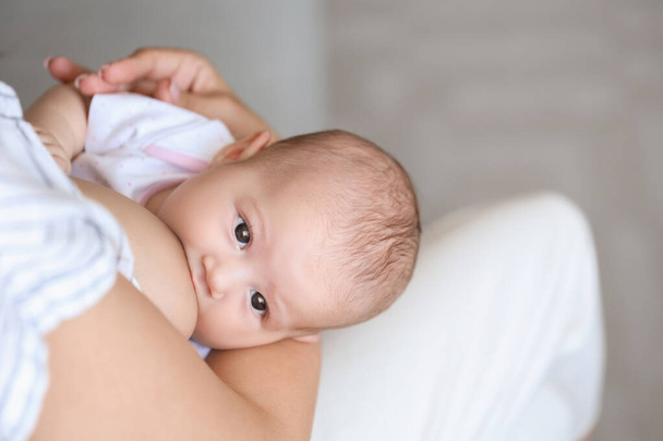 赤ちゃんを母乳で育てている若い女性が - 写真・画像