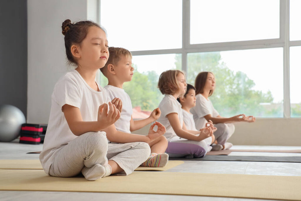 Skupina malých dětí meditujících v tělocvičně - Fotografie, Obrázek