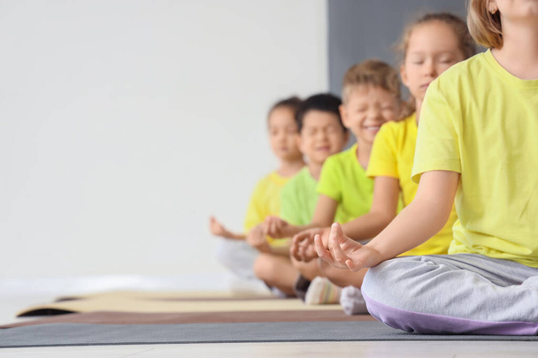 Skupina malých dětí meditujících v tělocvičně - Fotografie, Obrázek