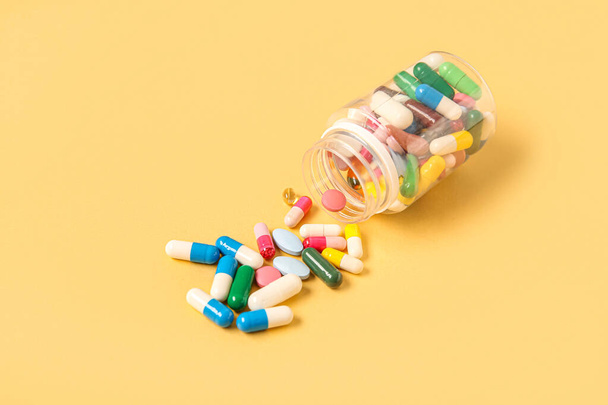 Βάζο με διαφορετικά χάπια σε κίτρινο φόντο - Φωτογραφία, εικόνα