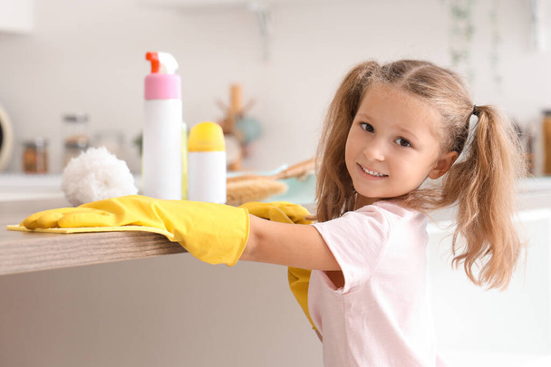 Nettes kleines Mädchen putzt Tisch in Küche - Foto, Bild