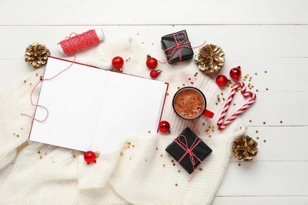 Samenstelling met mok koffie, blanco notitieboekje en kerstdecor op witte houten achtergrond - Foto, afbeelding