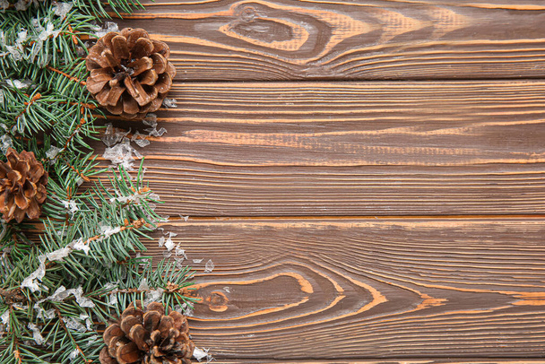Композиція з ялиновими гілками, конусами та снігом на дерев'яному фоні - Фото, зображення