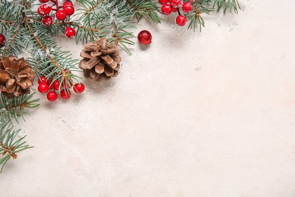 Χριστουγεννιάτικη σύνθεση με κλαδιά ελάτης, κώνους και κόκκινα μούρα σε ανοιχτό φόντο - Φωτογραφία, εικόνα