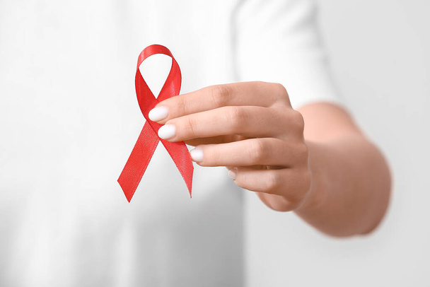 Woman with red ribbon on white background. AIDS Day concept - Photo, Image
