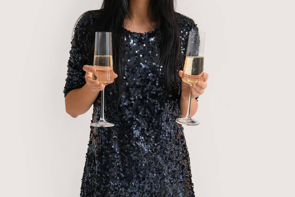 Hermosa joven con copas de champán sobre fondo blanco, primer plano - Foto, Imagen