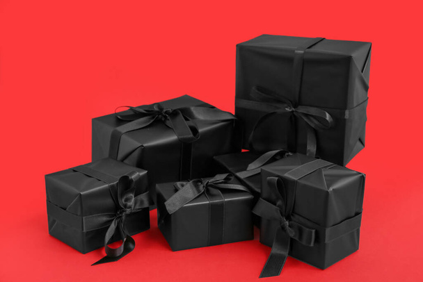Πολλά κουτιά δώρων σε κόκκινο φόντο. Μαύρη Παρασκευή - Φωτογραφία, εικόνα