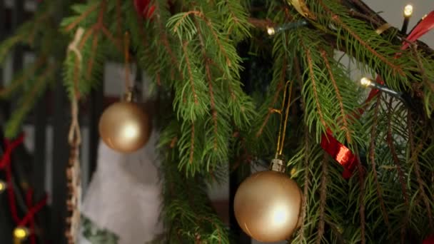 Detailní záběr vánoční výzdoby, stuhy, světlo, luky a vánoční stromeček zdobení dřevěné schodiště v domě na zimní prázdniny. - Záběry, video