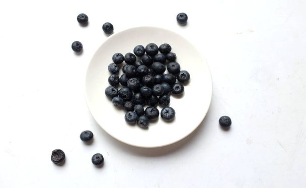 Fresh organic juicy blueberries,ripe sweet blueberry In a white circular ceramic dish isolate on a white backdrop. Blueberries background.  with copy space for your text. Vegan and vegetarian  Health - Photo, Image