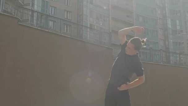 Medium linssi leimahti laukaus urheilullinen valkoihoinen kaveri tekee puoli mutkia ulkona kaupungissa aurinkoisena aamuna - Materiaali, video