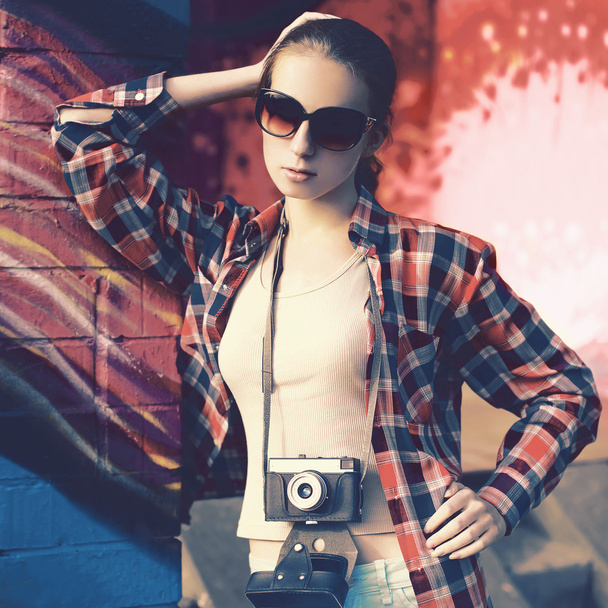Fashion portrait of stylish young woman with old retro camera ag - Фото, изображение