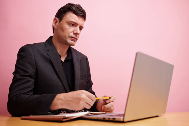 Erfolgreicher Unternehmer liest E-Mail seines Geschäftspartners am Laptop - Foto, Bild