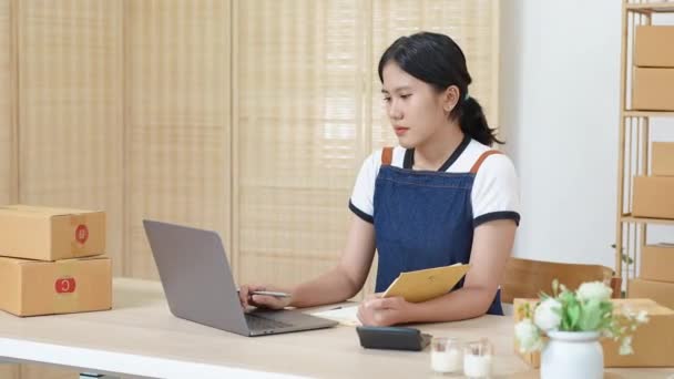 小さなスタートアップの肖像アジアの女性起業家、中小企業の所有者は、ターゲットセットに達していない収益に関する懸念を示す、販売を見るためにコンピュータのラップトップやノートブックを使用しています。高品質4k - 映像、動画