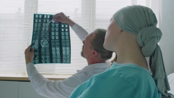 Sobre o ombro do paciente e do médico falando sobre a varredura de imagem de raio-X do cérebro enquanto sentado na enfermaria do hospital - Filmagem, Vídeo