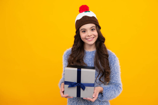 Emotionale Teenager-Kind halten Geschenk zum Geburtstag. Lustiges Mädchen mit Geschenkschachteln, die ein frohes neues Jahr oder Weihnachten feiern. Glücklicher Teenager, positive und lächelnde Gefühle eines Teenie-Mädchens - Foto, Bild