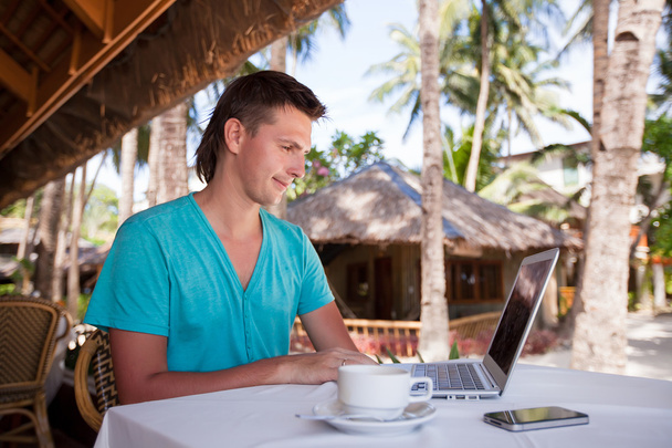 Giovane uomo d'affari che utilizza laptop durante le vacanze tropicali estive
 - Foto, immagini