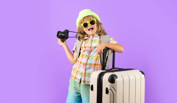 Turista infantil con bolsa de viaje de viaje. Niño con maleta en el estudio de fondo aislado - Foto, Imagen